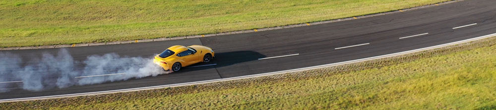 Un deportivo amarillo en un circuito de handling en seco durante una prueba de Tyre Reviews de neumáticos de ultra alto rendimiento