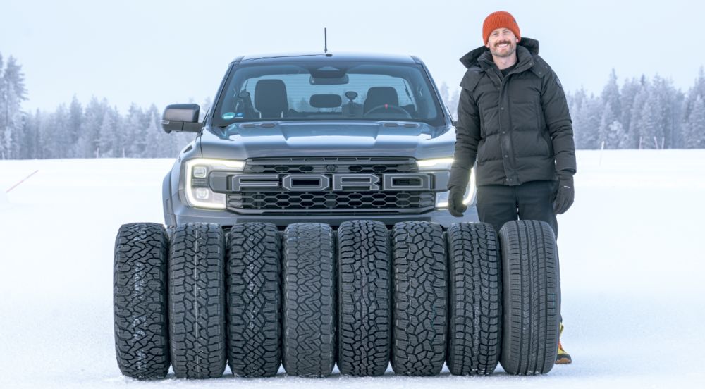 Neumáticos todo terreno alineados sobre la nieve delante de una pick-up Ford en una prueba de neumáticos de invierno