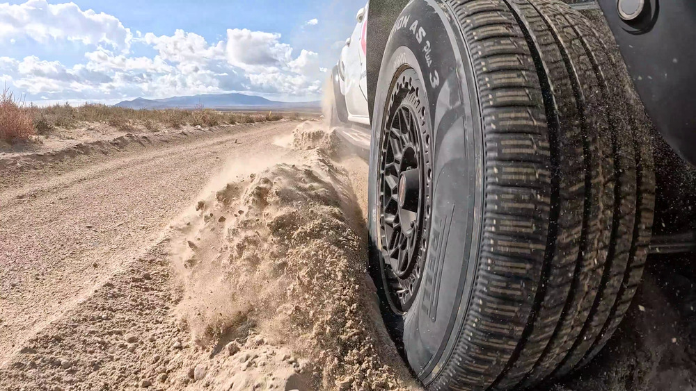 Neumático Pirelli Scorpion AS Plus 3 levantando arena suelta junto a un Ford Ranger Raptor