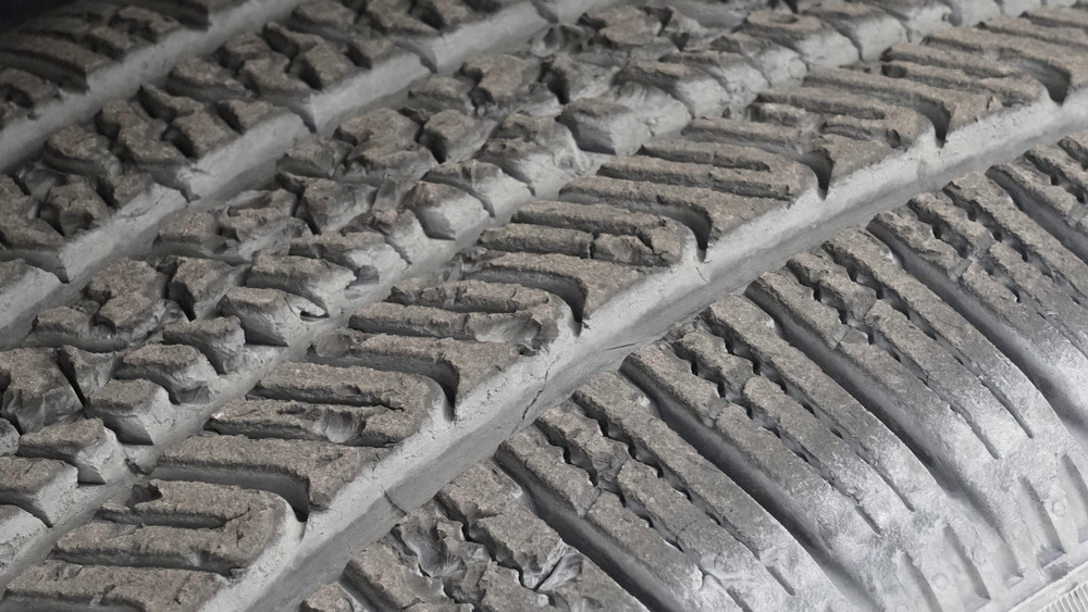 Primer plano de los tacos astillados y desgarrados de la banda de rodadura del Pirelli Scorpion AS Plus 3 después de las pruebas fuera de carretera